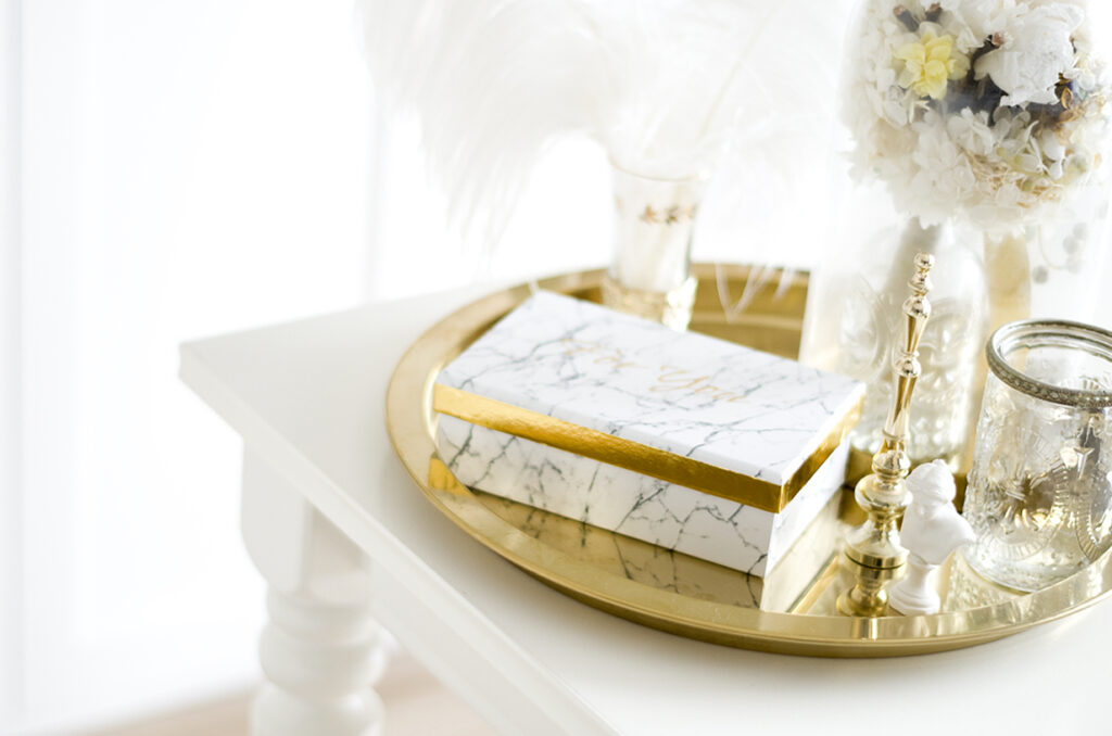 白いダイニングテーブルの上のゴールドトレイとインテリア雑貨